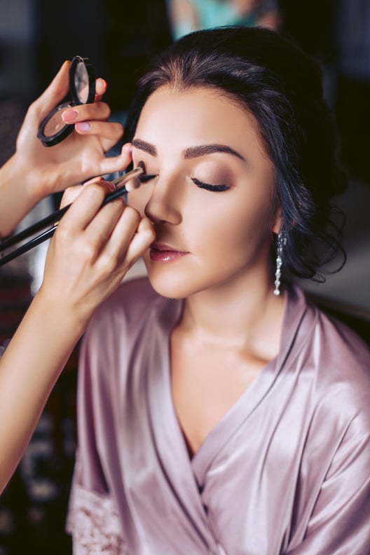 A beautiful bride makeup artist applies makeup. Wedding morning of the bride